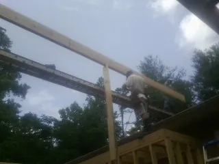 Carpenter setting a ridge beam over a new addition frame — Ice Dam Removal by Roofing Brothers in Sturgeon Bay