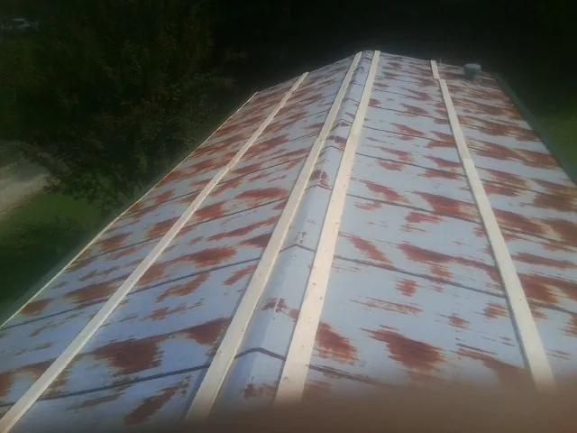 Rusted metal roof panels with new wood purlins before replacement — Storm Damage Roof Repair in Sturgeon Bay by Roofing Brothers