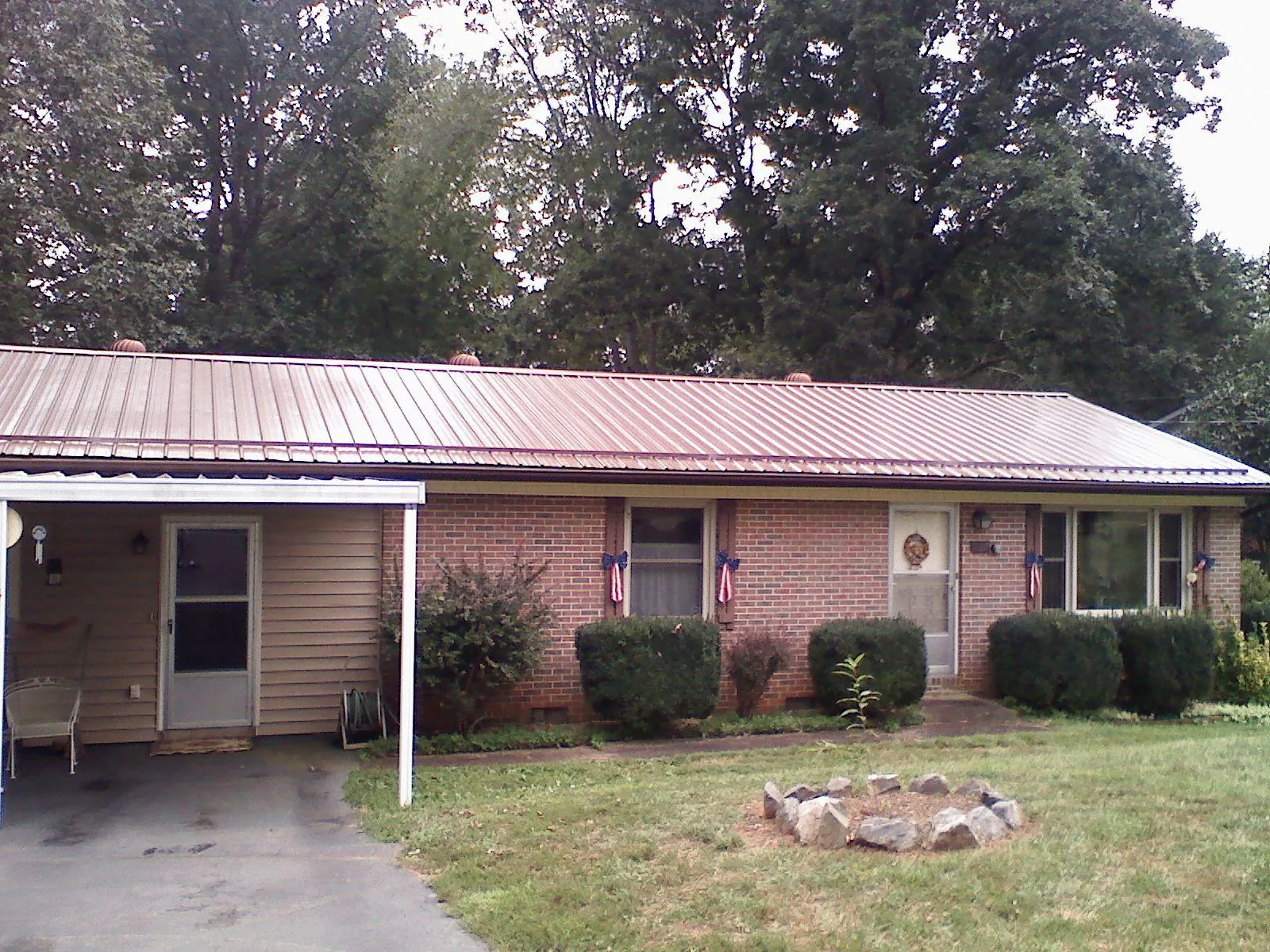 Bronze metal roof and carport on a brick ranch home — Roof Repair work by our crew in Sturgeon Bay