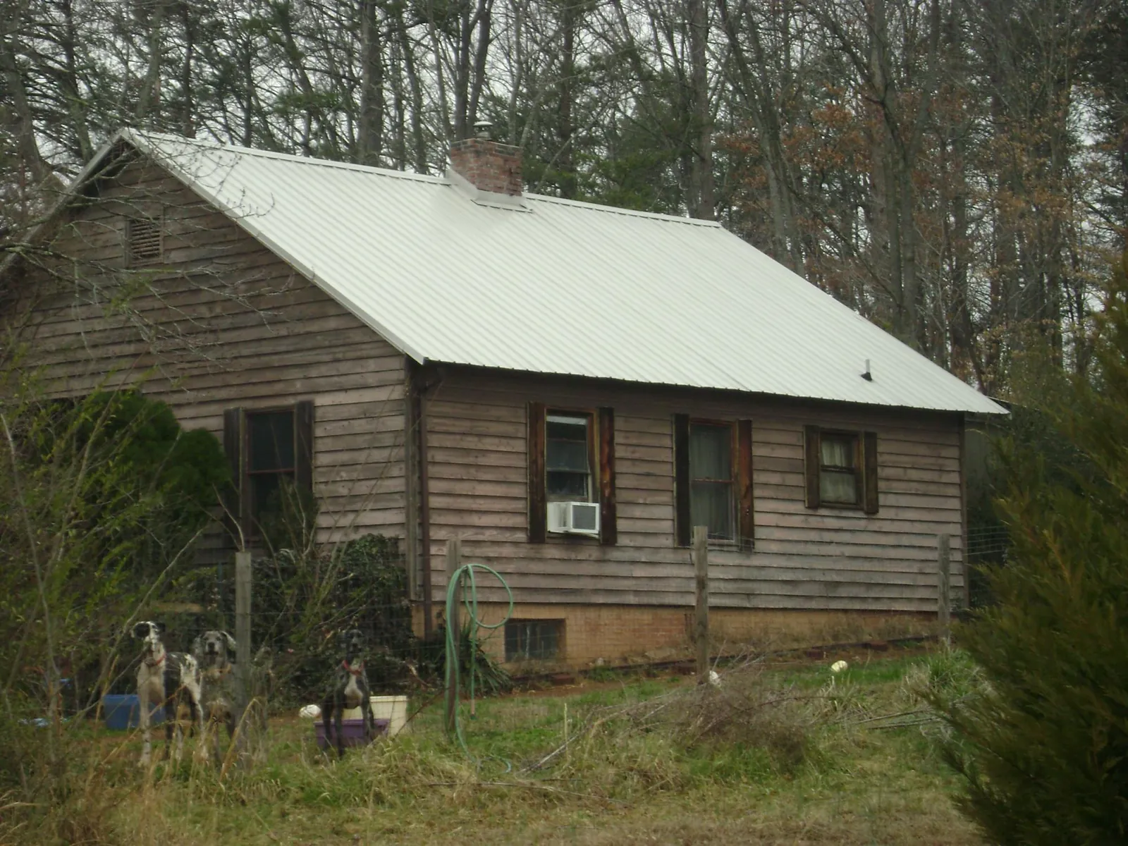 White metal roof on an old wood sided farmhouse, from a Metal Roof Installation job in Sturgeon Bay